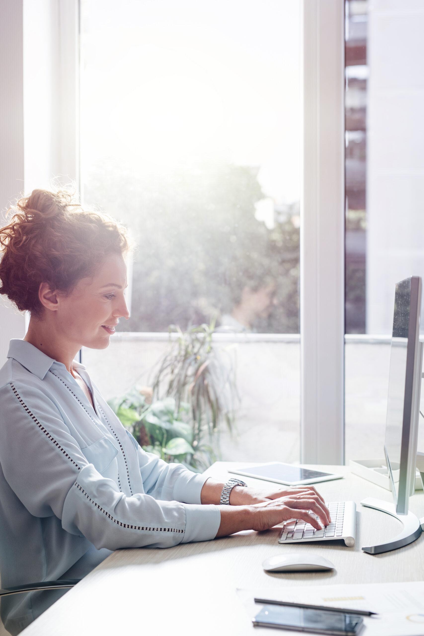 Young businesswoman working on a desktop computer at the modern office space.